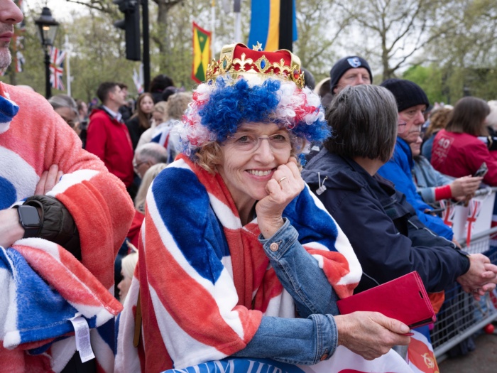 Abbie Trayler-Smith  Members of the public watch the procession past along the Mall at the Coronation of King Charles III and Queen Camilla in Central London, UK.
